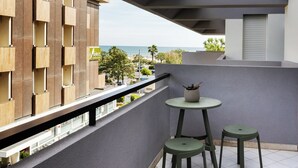 A balcony with a view of the sea, a small round table, two chairs, and a potted plant. - Carinzia Comfort Plus 8 - Riviera Collection (RICCIONE)