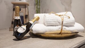 Eine Flasche Maschio Prosecco auf einem Tablett mit gefalteten weißen Handtüchern, die mit Bindfaden gebunden sind.