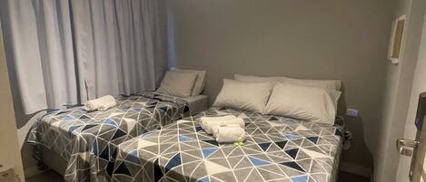 Habitación de hotel con dos camas, un baño y una puerta.