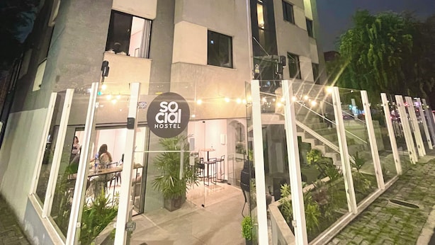 Ein modernes Hostel mit Glastür, Außenbereich und einer Treppe zum Eingang.