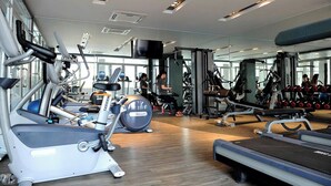A gym with cardio machines, weightlifting equipment, and a mirrored wall. - Apartment in District 7 Near SECC (Thành phố Hồ Chí Minh)
