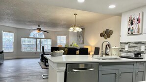 A spacious kitchen with a central island, modern appliances, and a dining area with a view of the outdoors.