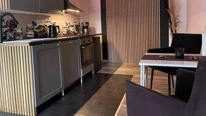 Eine moderne Küche mit einer zentralen Kochinsel, Einbauofen und einem Essbereich mit Tisch und Stühlen.