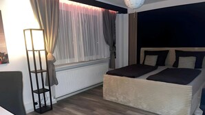 Ein modernes Schlafzimmer mit einem großen Bett, einer Stehlampe und einer Heizung.