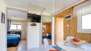 Moderni hotellihuone, jossa on sänky, työpöytä ja ruokailutila.