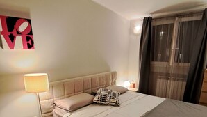 A bedroom with a bed, bedside tables, a lamp, a rug, and a wall decoration. - Lovely and Charming Nest close to Porta Romana (Milano)