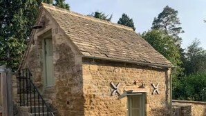 A stone building with a pitched roof, a green door, and a small staircase leading to the entrance. - Little Rissington, Pets, Parking, Sleeps 2 (Cheltenham)