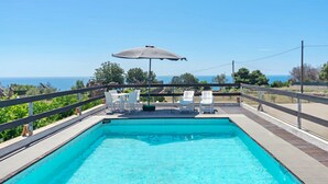 A rectangular swimming pool with a wooden deck and white lounge chairs. - Villetta Murena - Con Piscina Privata E Vista Mare (Corsano)