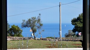 A coastal view with a stone wall, a warning sign, and a utility pole. - Villetta Murena - Con Piscina Privata E Vista Mare (Corsano)