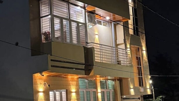A multi-story building with balconies and windows illuminated at night. - Brightness in the Sky – A Cozy, Peaceful Stay with Modern Comforts (Jaipur)
