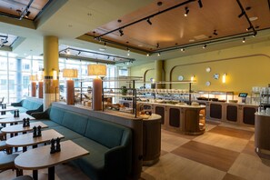 A modern dining area with a buffet, seating, and a view of the city. - Scandic Charlottenburg (Berlin)