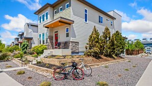 A two-story house with a front porch, a driveway, and a bicycle parked outside. - Casa Tierra | Walk to Old Town via Poudre Trail (Fort Collins)