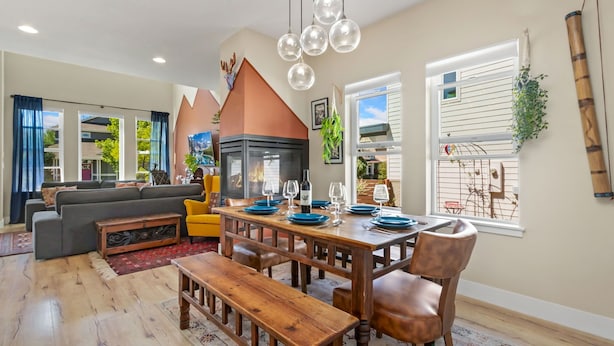 A modern living room with a sofa, dining table, and benches. - Casa Tierra | Walk to Old Town via Poudre Trail (Fort Collins)