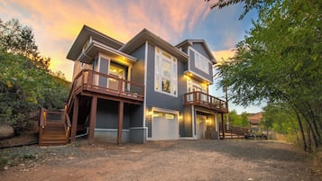 A two-story house with a front deck and a garage.