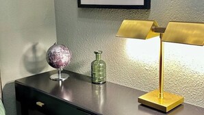 A desk with a globe, a green bottle, and a gold lamp. - Vacation apartment Luna (Teltow)