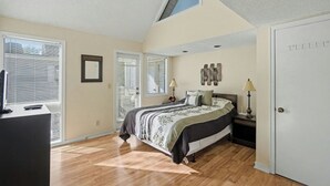 A bedroom with a bed, bedside tables, a desk, and a window with blinds. - Arcadian Dunes 11 #343- 2BR- Pool, Hot Tub (Myrtle Beach)