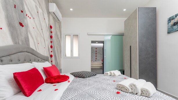 A modern bedroom with a bed, pillows, and towels. - Pm House - Suite with Jacuzzi (Misterbianco)