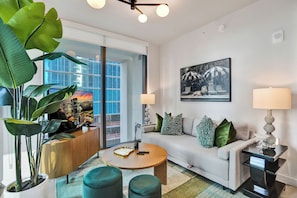 A modern living room with a sofa, coffee table, and potted plants. - The Crosby by Nomada (Miami)