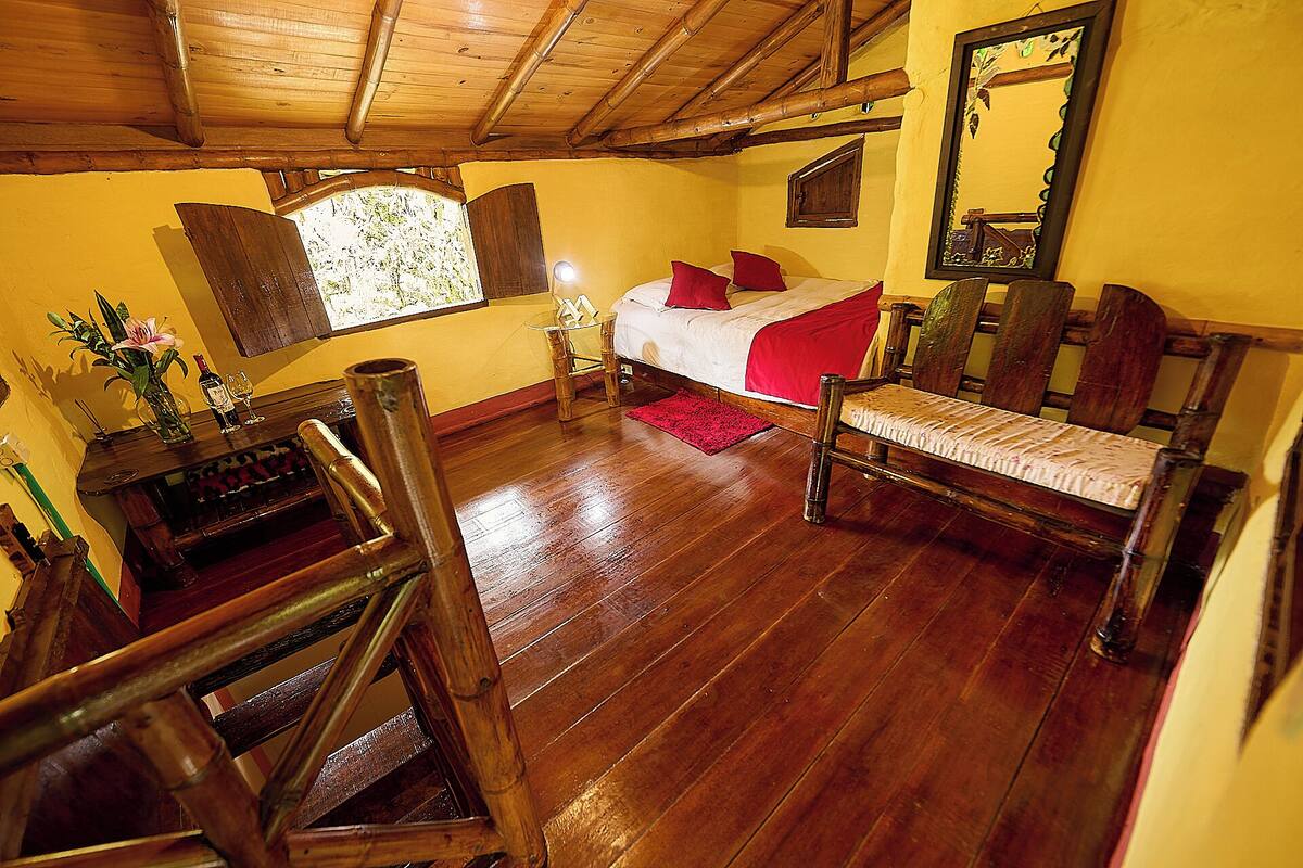 Une chambre avec un lit, des meubles en bois, un miroir et une fenêtre donnant sur un paysage agréable.