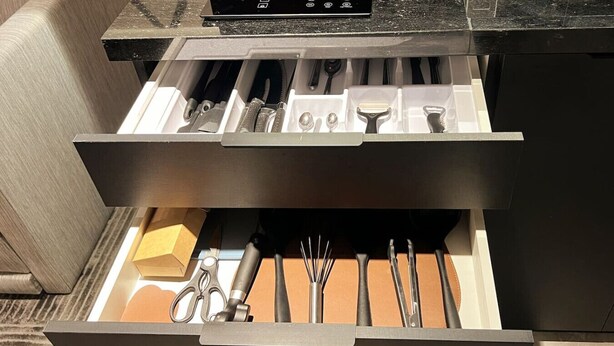 A drawer with various kitchen utensils and tools, including scissors, a whisk, and a spatula. - DOru Vila Nova Conceição by Wecare (São Paulo)