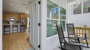 A kitchen with wooden cabinets, a stainless steel refrigerator, and a microwave. - Brand New Immaculate Cottage (Saint Augustine)