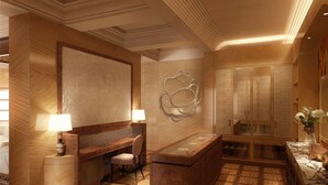 A hotel lobby with a reception desk, seating area, and a large mirror. - The Red Palace (Riyadh)