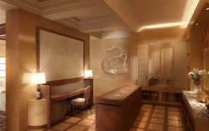 A hotel lobby with a reception desk, seating area, and a large mirror. - The Red Palace (Riyadh)