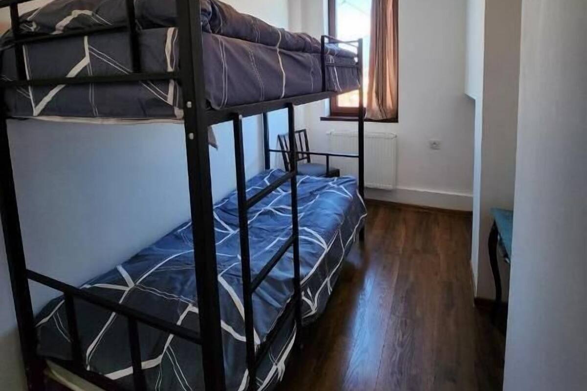 A bunk bed room with a window and a radiator.