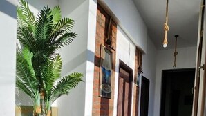 A hallway with a brick wall, wooden floor, and a potted plant. - City Guli  (Tbilisi)