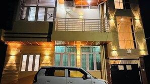 A two-story building with a car parked in front. - A Little Peaceful Retreat – Your Cozy Home Away From Home (Jaipur)