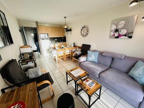 A modern living room with a sofa, coffee table, and dining area. - Apartment for 4–6 people with port view, Port Bourgenay (Talmont-Saint-Hilaire)