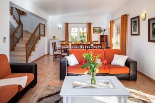 Una sala de estar con sofá, mesa de centro y una escalera.