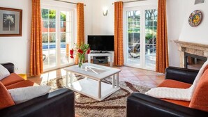 A living room with a TV, sofa, and coffee table.