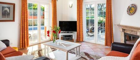 Un salon avec un téléviseur, un canapé et une table basse.
