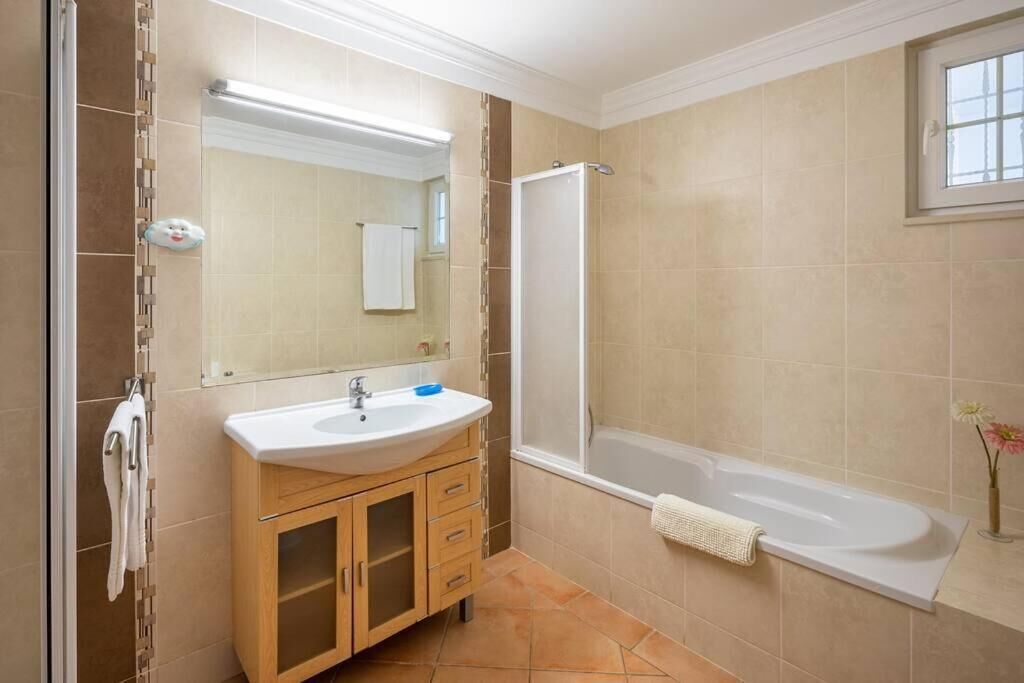 Un baño con bañera, lavamanos y ducha.