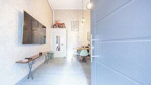 A hallway with a bench, a table, chairs, and a motorcycle.