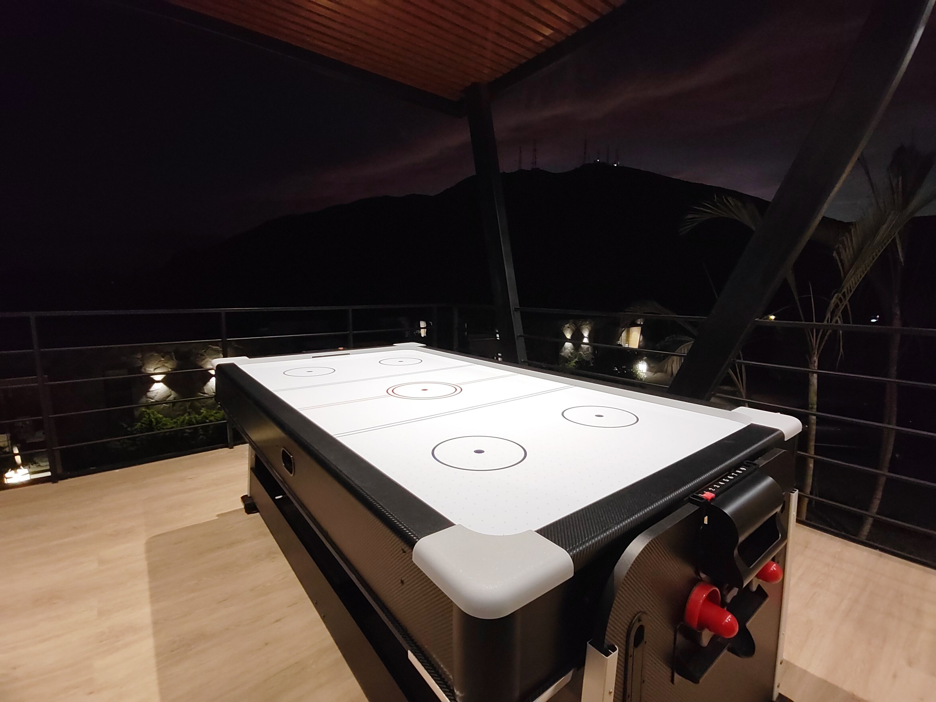 An outdoor pool table with four white playing surfaces and a black table edge.