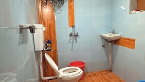 Une petite salle de bain avec des toilettes, un lavabo et une douche.
