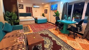 Une chambre d’hôtel avec un lit, un canapé, un bureau et une télévision.