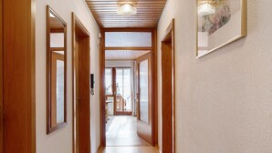 A hallway with wooden doors, a ceiling light, and a framed picture on the wall. - Apartment 'Weideglück' with Shared Garden, Balcony and Wi-Fi (Feldberg-Altglashütten)