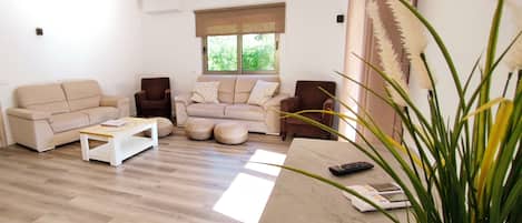 Ein Wohnzimmer mit zwei Sofas, einem Couchtisch und einem Fernseher.
