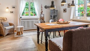 Un espace repas comprenant une table en bois, des chaises et des luminaires suspendus.