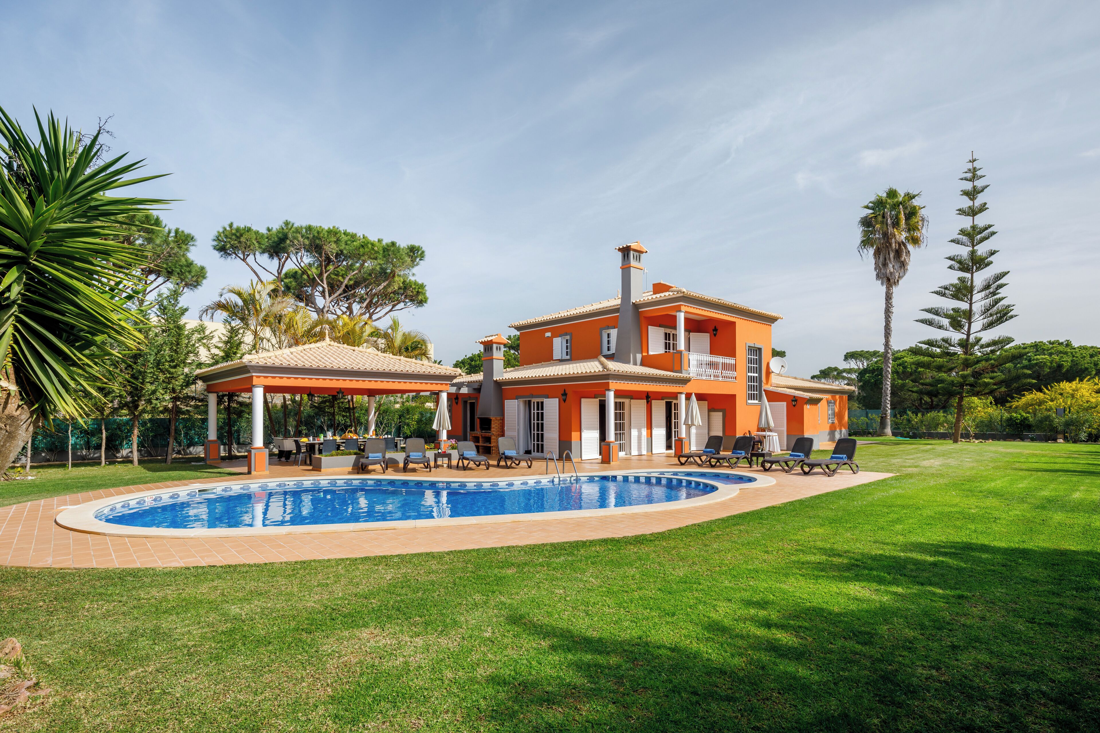 Una piscina al aire libre, sombrillas, tumbonas
