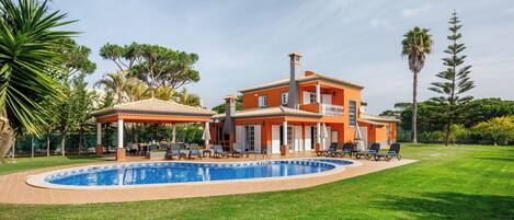Una piscina al aire libre, sombrillas, tumbonas