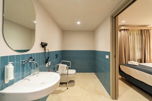 Un baño con lavamanos, espejo e inodoro.