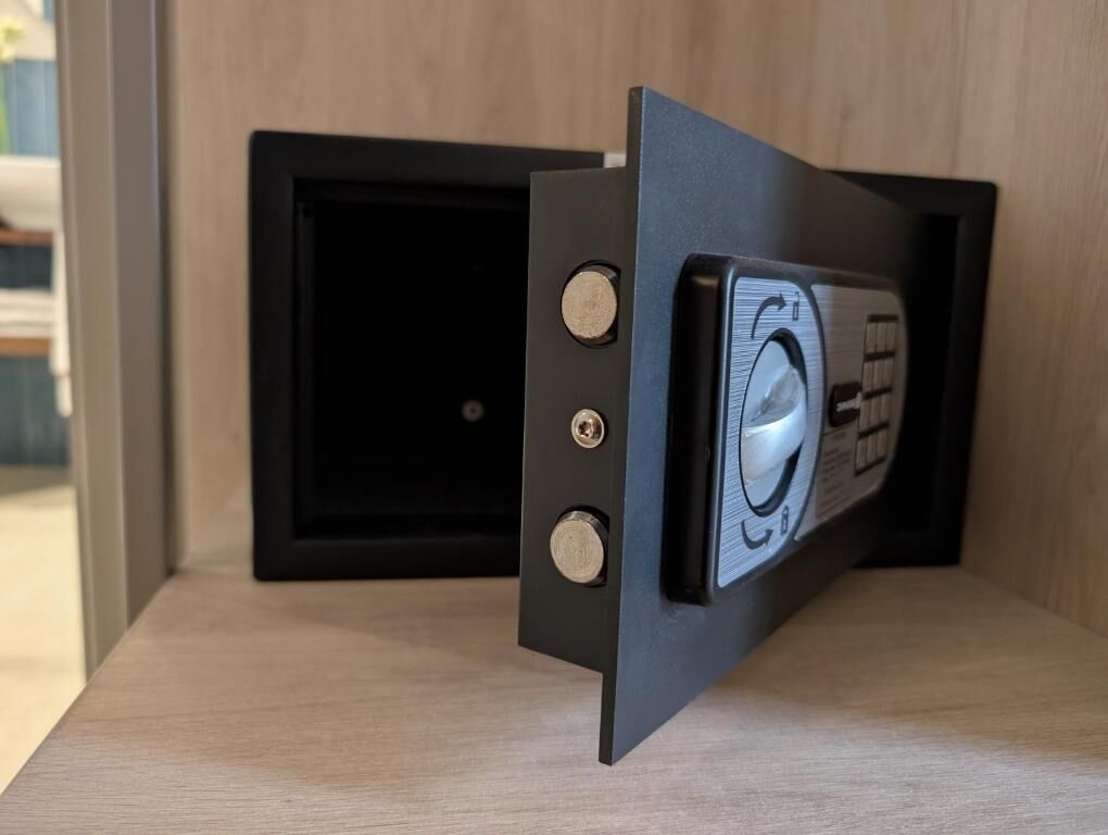 A black-framed object with two visible screws and a circular component on a wooden surface.