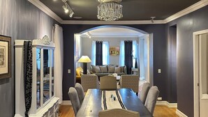 Un espace repas comprenant une grande table, des chaises et un lustre.