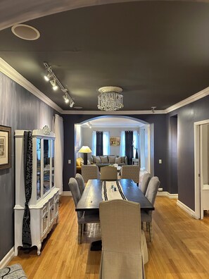 A dining area with a large table, chairs, and a chandelier. - Spacious 7-bedroom house in gorgeous Lincoln Park Chicago with AC (Chicago)