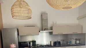 A modern kitchen with a dining area, including a refrigerator, microwave, stove, and seating.