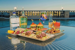 A table with food and drinks by a poolside. - New! Seven Eagles Hideaway at Reunion Resort (Kissimmee)